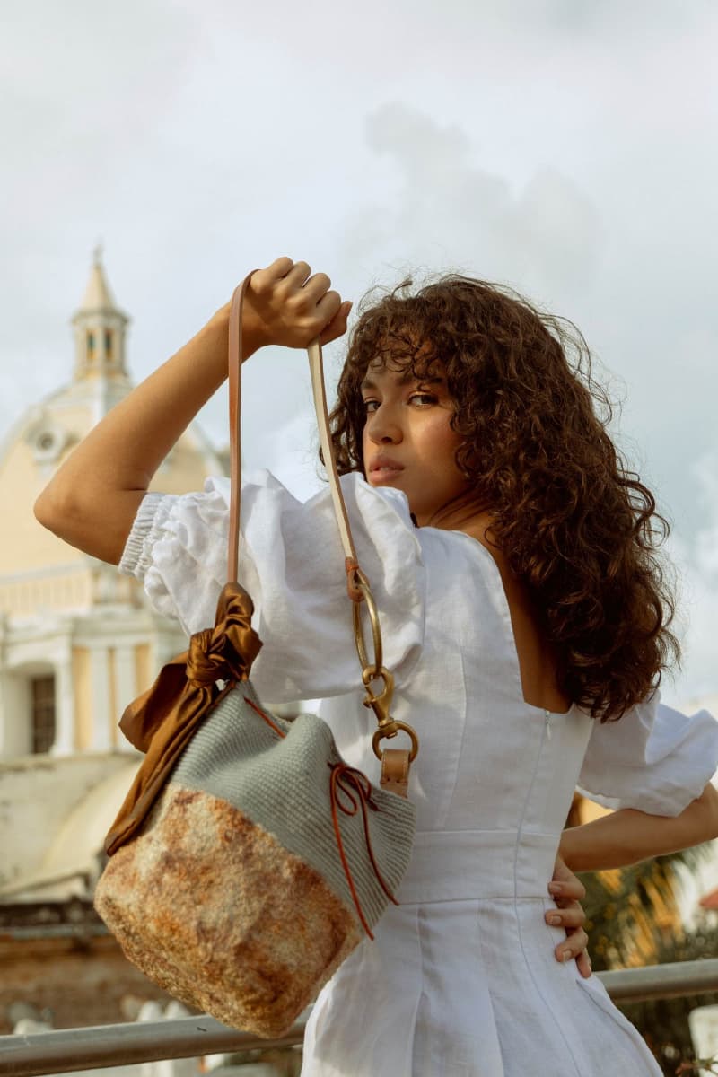Model posing elegantly with a Wayuu handbag